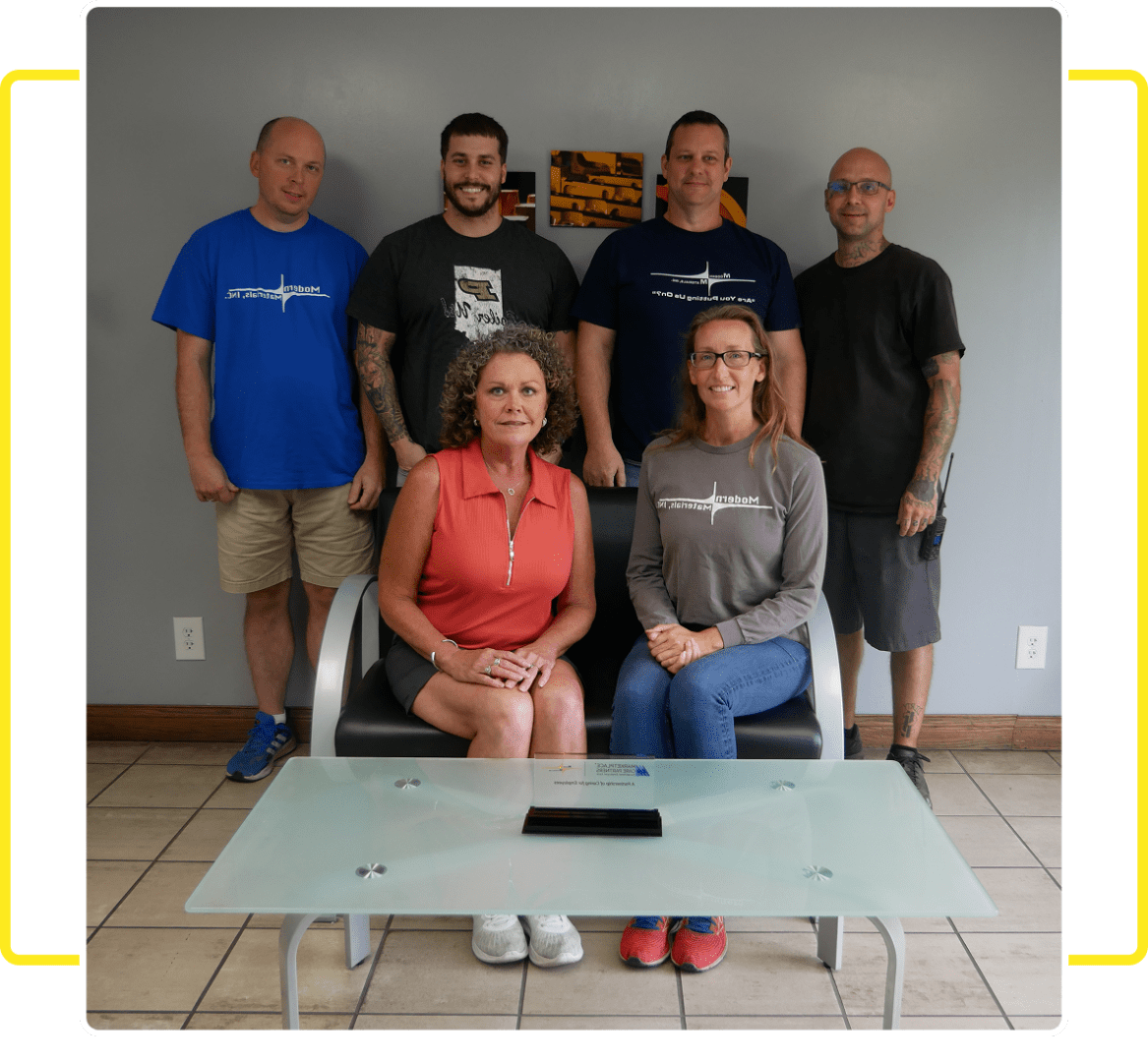 Team sitting and standing around table