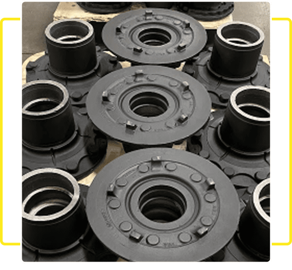 Stacked black mechanical parts with detailed surfaces and circular openings.