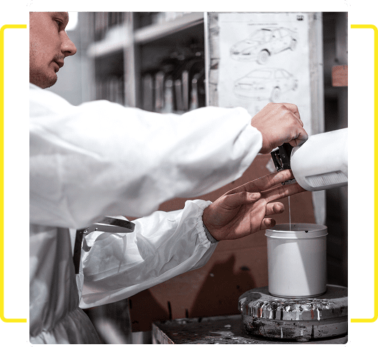 Scientist pouring liquid into a container in a lab setting.