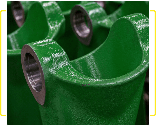 Close-up of green painted metal parts with threaded holes.